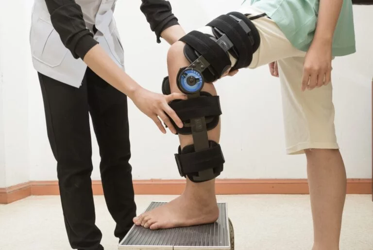 A patient doing knee rehab exercises with a therapist after surgery