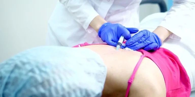 A woman receiving a pain management injection in her lower back