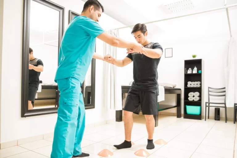 A patient working with a therapist during a neurological rehab session