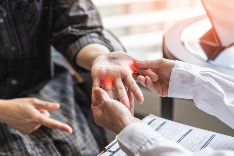 image of a patient with an injury in their hand - a doctor evaluating it