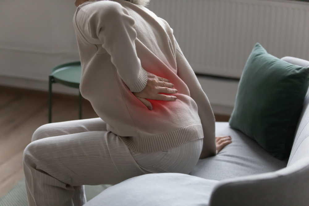 a picture of a woman holding her back due to sciatica pain